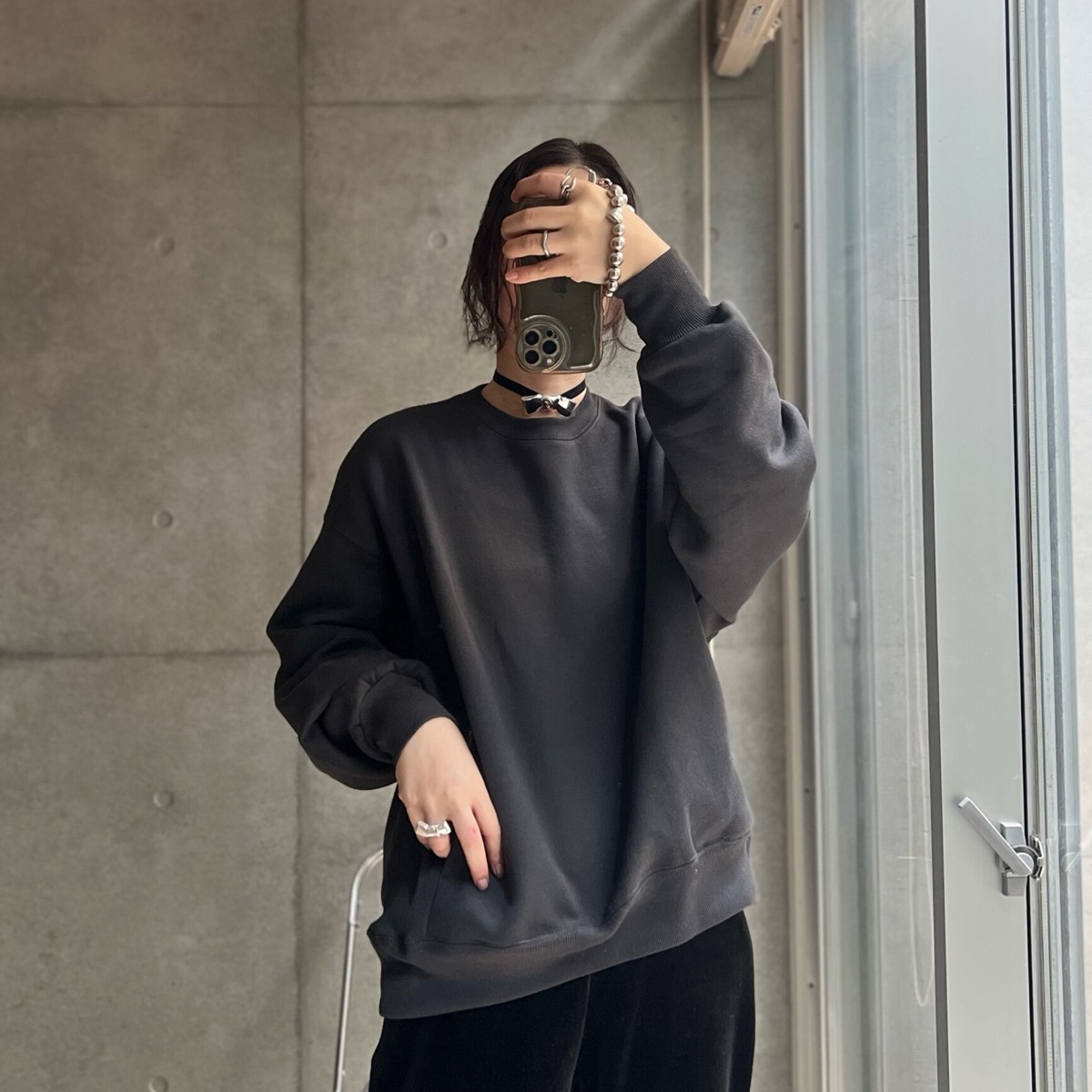 アンドミーの裏起毛オーバーサイズスウェット（スミクロ）を黒パンツに合わせた着画。ダボっとした身頃と詰まったネック