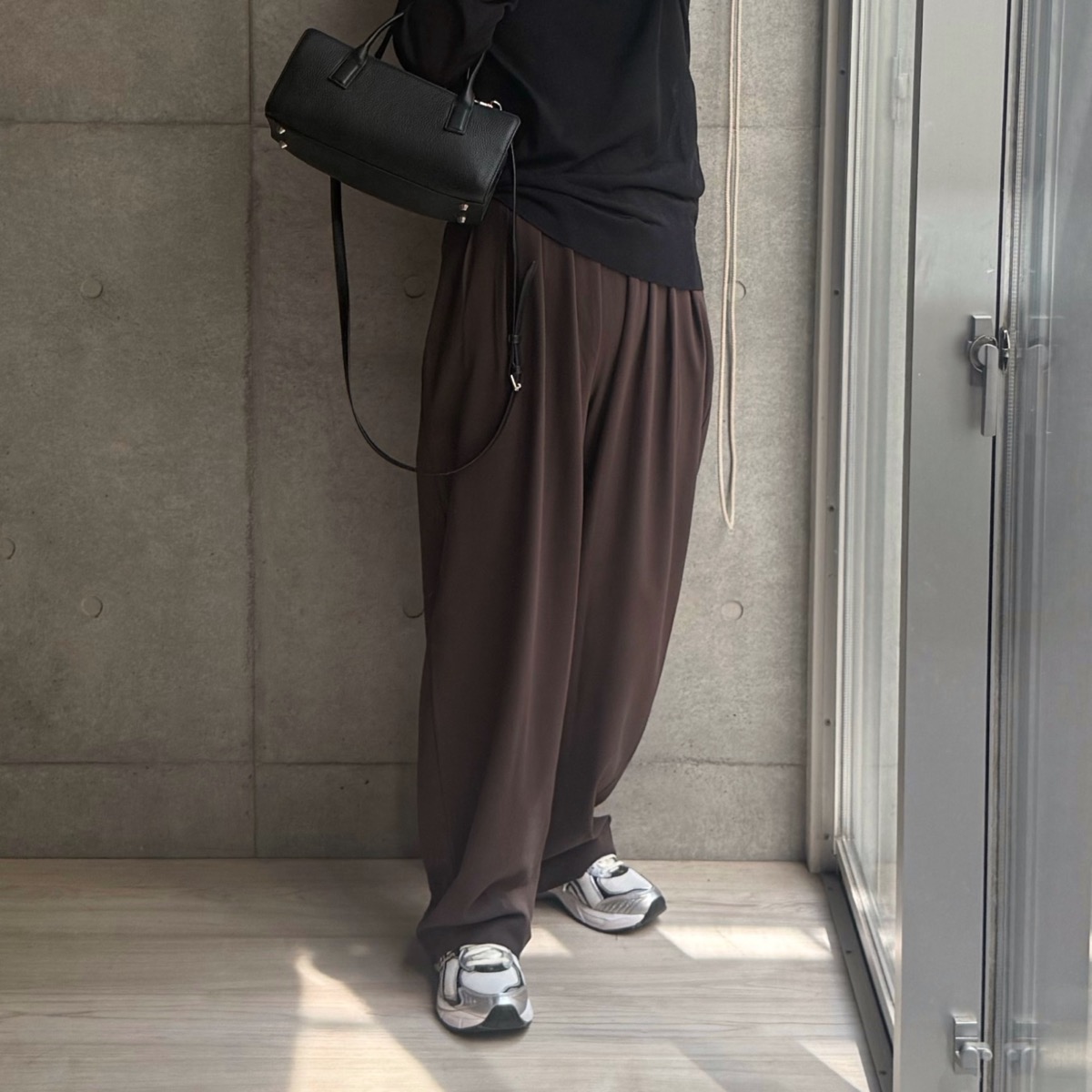 4本タックワイドパンツ ブラウンに黒トップスとシルバースニーカーを合わせたコーデ