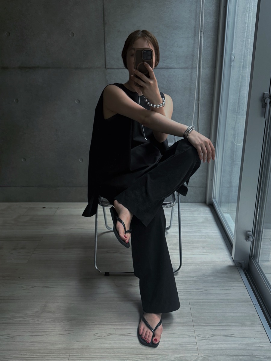 黒のノースリーブと黒のパンツに、ハワイアナス スリムスクエアを合わせた全身コーデ