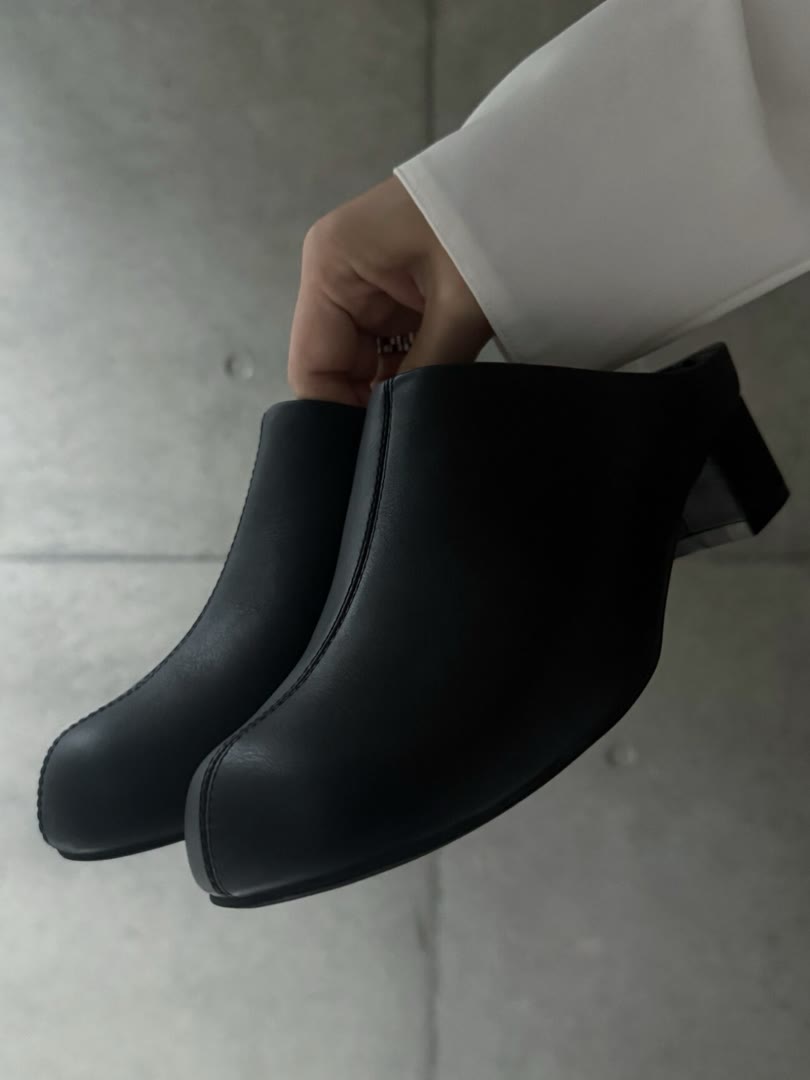 I NEED MORE SHOESのオブリークトゥサボ ブラックを手に持ったところ。先が丸いオブリークトゥ
