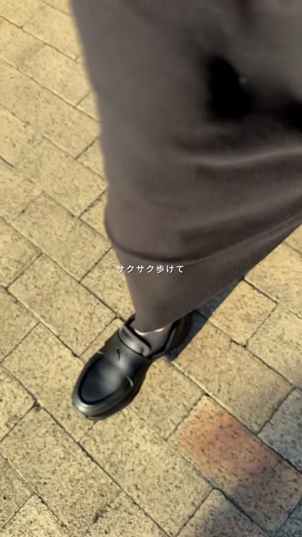 ブラウンのワイドパンツの裾から見えるPUMAローファー。石畳を歩いているところ